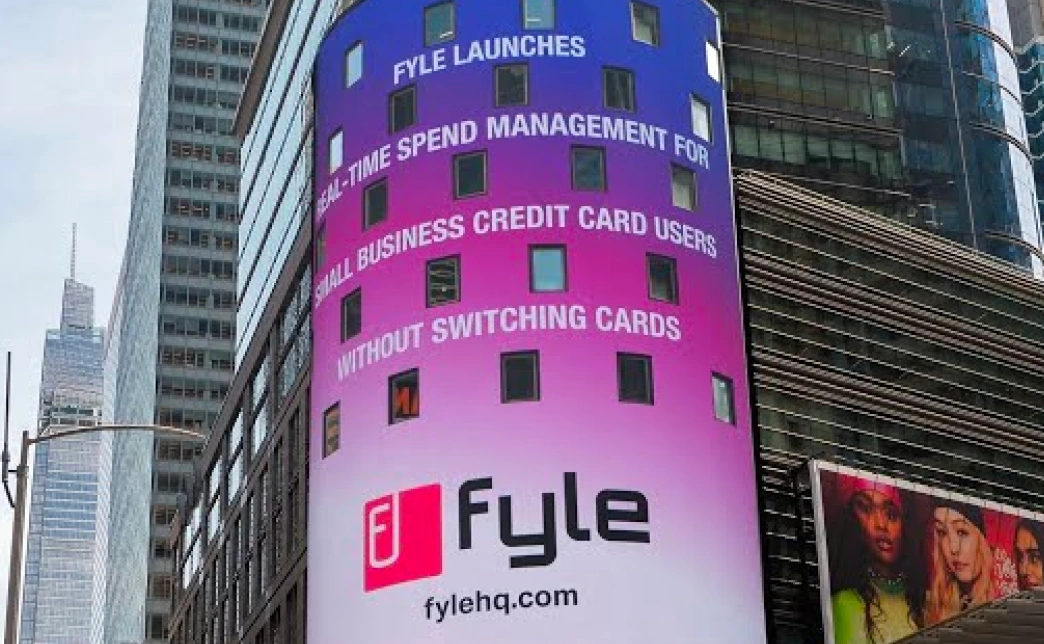 A Fyle advertisement on a digital billboard in Times Square, signifying the Visa partnership.